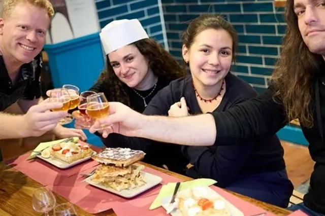 Participantes brindando con cerveza belga junto a los gofres que prepararon en el taller