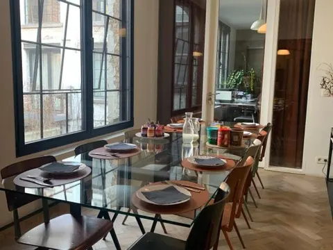 Eetkamer met glazen tafel en kunstzinnige inrichting in B&B DRUUM, Brussel