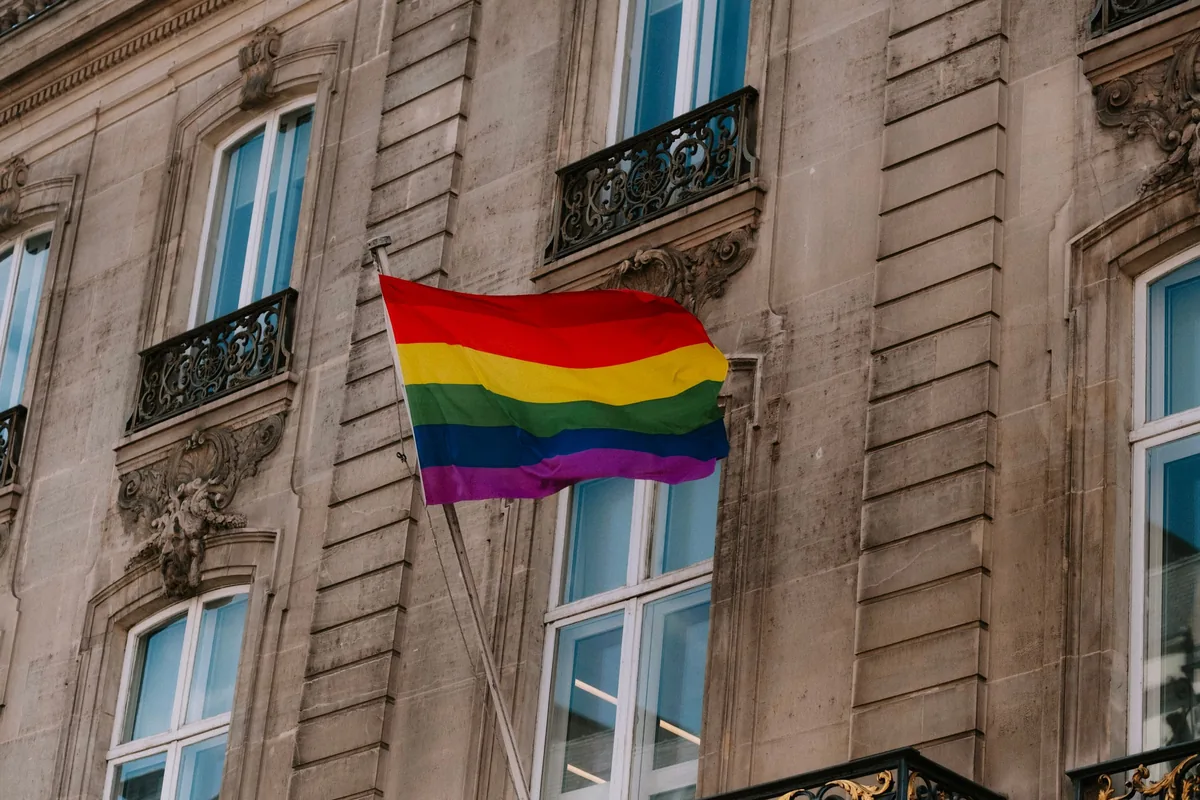 Bandera arcoíris colgada en la fachada de un edificio
