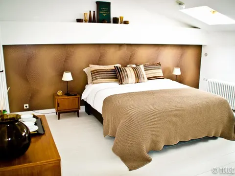 Kamer met decoratief hoofdbord en schuin dak in House Ninety, Elsene