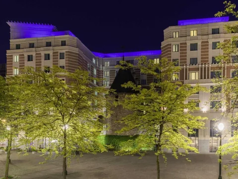 Gevel van Novotel Brussels City Centre bij nacht, met de middeleeuwse toren
